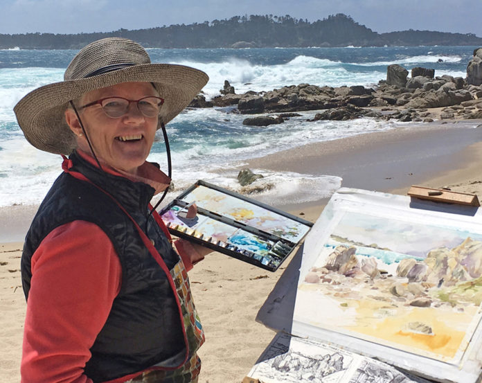 Woman artist painting on the beach