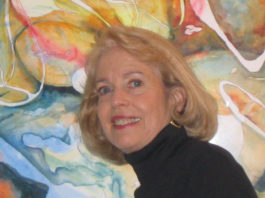 Woman artist in front of one of her paintings